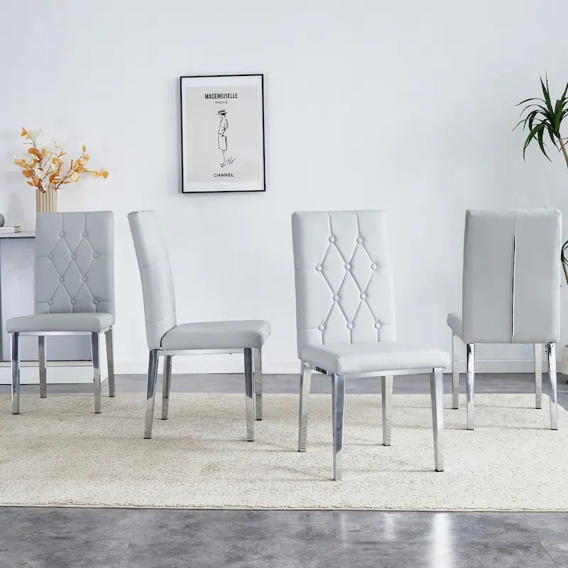 Chaise de salle à manger grise sans accoudoirs, avec dossier capitonné à motif quadrillé et clouté, et pieds en métal argenté.