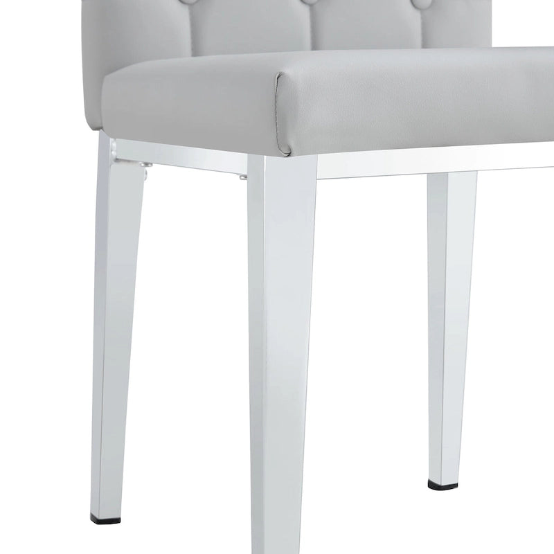 Chaise de salle à manger grise sans accoudoirs, avec dossier capitonné à motif quadrillé et clouté, et pieds en métal argenté.