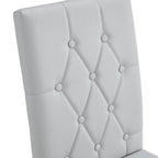 Chaise de salle à manger grise sans accoudoirs, avec dossier capitonné à motif quadrillé et clouté, et pieds en métal argenté.