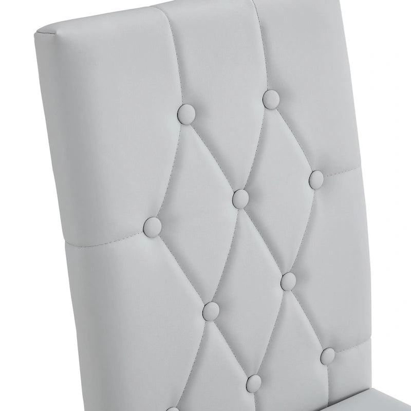 Chaise de salle à manger grise sans accoudoirs, avec dossier capitonné à motif quadrillé et clouté, et pieds en métal argenté.