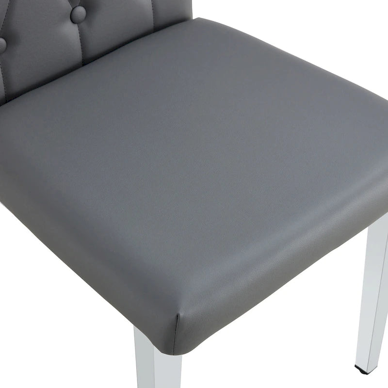 Chaise de salle à manger grise sans accoudoirs, avec dossier capitonné à motif quadrillé et clouté, et pieds en métal argenté.