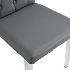 Chaise de salle à manger grise sans accoudoirs, avec dossier capitonné à motif quadrillé et clouté, et pieds en métal argenté.