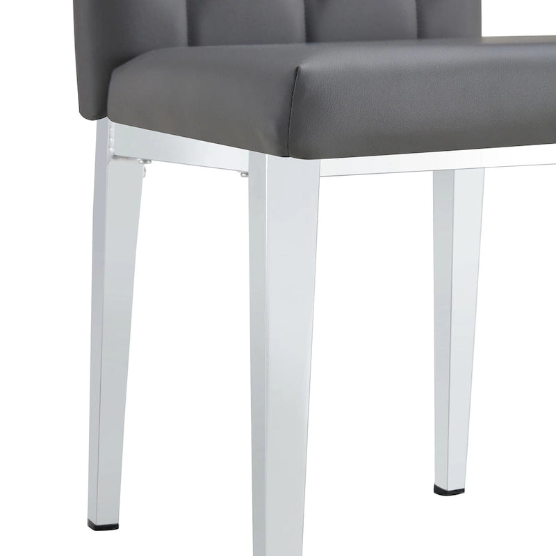 Chaise de salle à manger grise sans accoudoirs, avec dossier capitonné à motif quadrillé et clouté, et pieds en métal argenté.